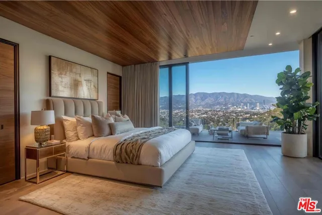 a spacious bedroom with a large bed and a potted plant