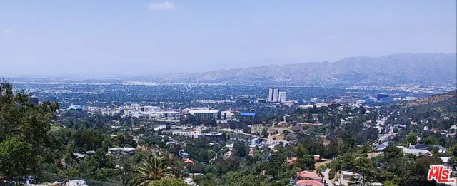an aerial view of house with yard and mountain view in back