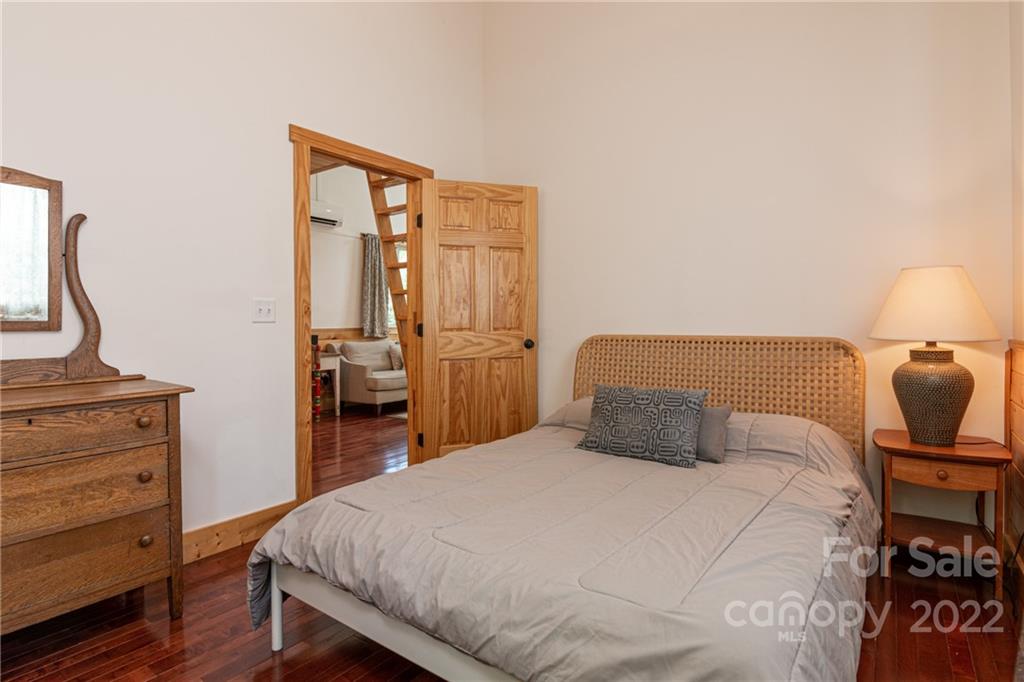 29 Davidson Road Asheville, NC 28803 - Photo 21 of 37 a bedroom with a bed and wooden floor
