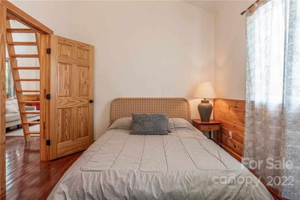 29 Davidson Road Asheville, NC 28803 - Photo 22 of 37 a bedroom with a bed and wooden floor