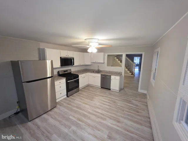 a kitchen with a refrigerator and a stove top oven