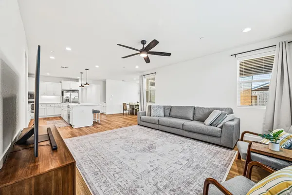 a living room with furniture kitchen view and a chandelier