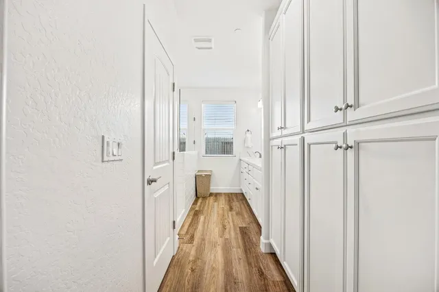 a view of a hallway with wooden floor and staircase