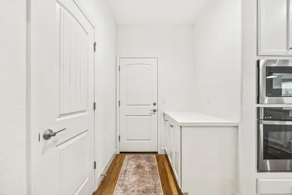 a view of a hallway with closet and a window