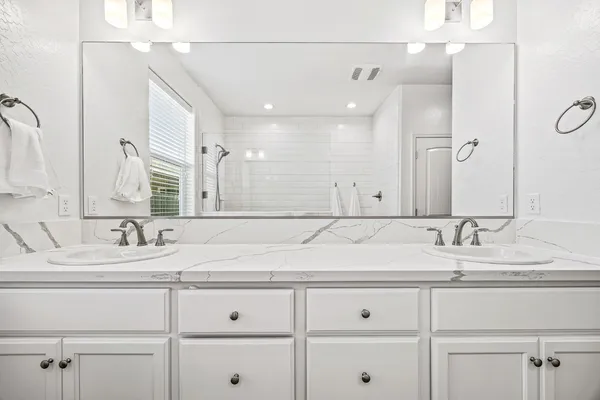 a bathroom with double sink and a mirror