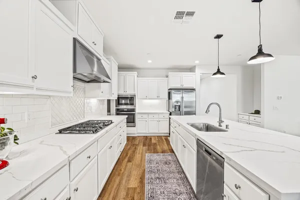 a large kitchen with stainless steel appliances lots of counter space sink and cabinets