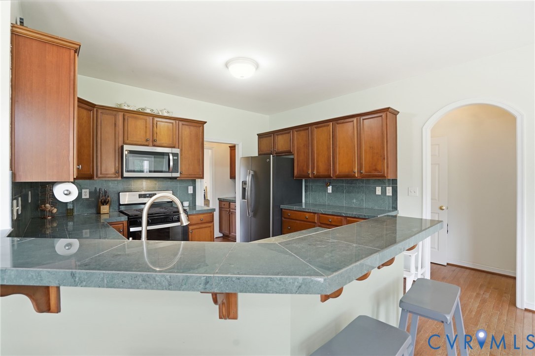 5305 Wellington Ridge Road Richmond, VA 23231 - Photo 19 of 67 U-shaped kitchen featuring wood cabinetry, stainle