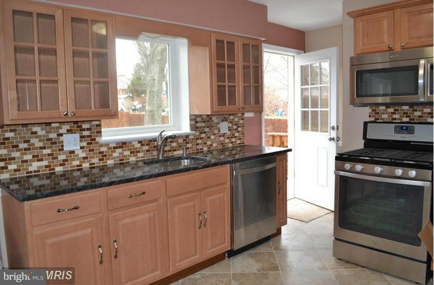 6022 Brunswick Street Springfield, VA 22150 - Photo 5 of 24 a kitchen with stainless steel appliances granite countertop a stove a sink and a microwave