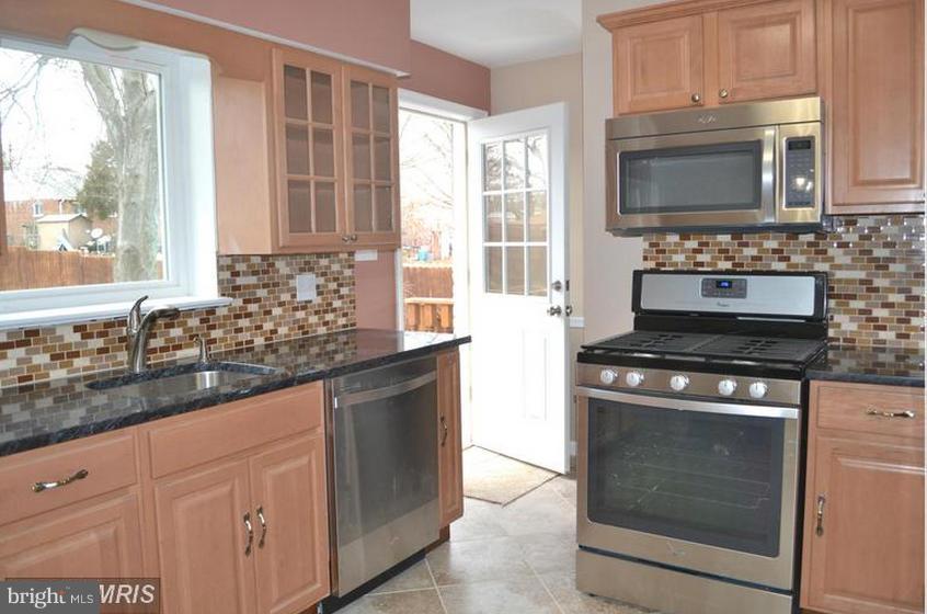 6022 Brunswick Street Springfield, VA 22150 - Photo 8 of 24 a kitchen with granite countertop a stove top oven microwave and sink