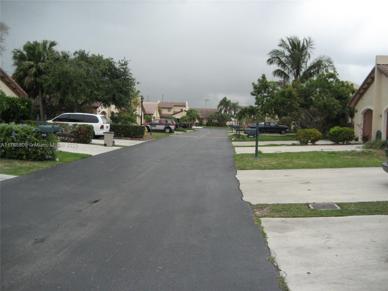 8589 Southwest 115th Place Miami, FL 33173 - Photo 11 of 13 a view of a street with a car parked in front of it