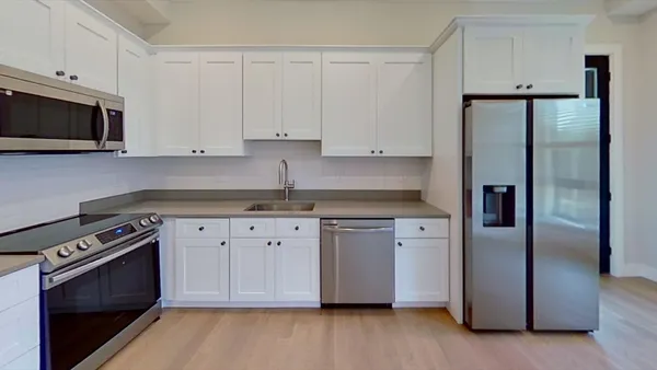 a kitchen with stainless steel appliances granite countertop a refrigerator a stove and a microwave