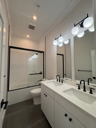 a bathroom with a double vanity sink mirror and toilet