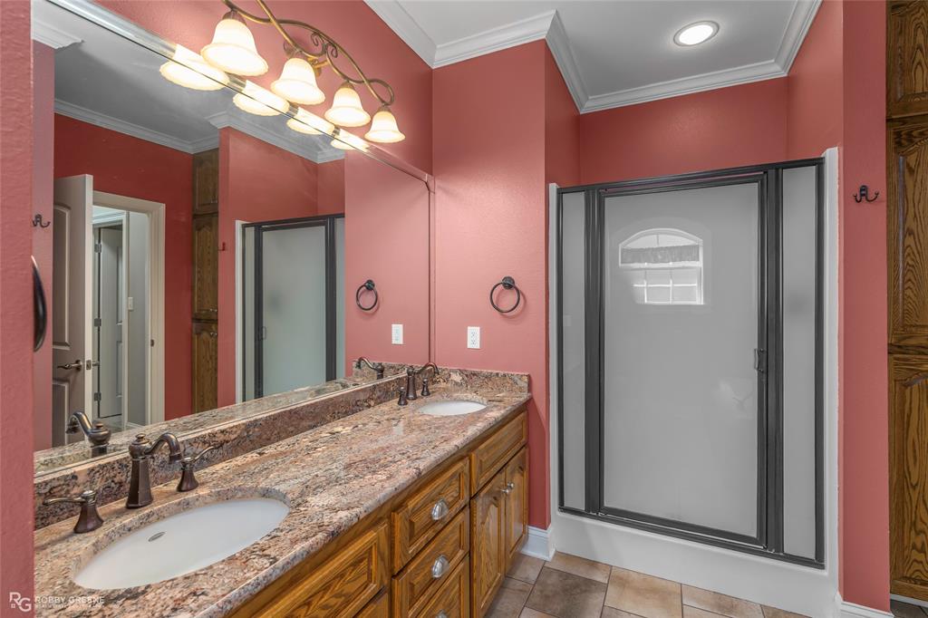 703 Airport Loop Homer, LA 71040 - Photo 16 of 32 a bathroom with a granite countertop sink a large mirror and a shower
