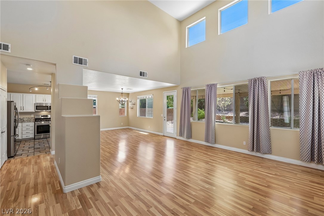 1727 Millstream Way Henderson, NV 89074 - Photo 10 of 46 A spacious great room features rich hardwood flooring and sun-filled windows framing the outdoor views.