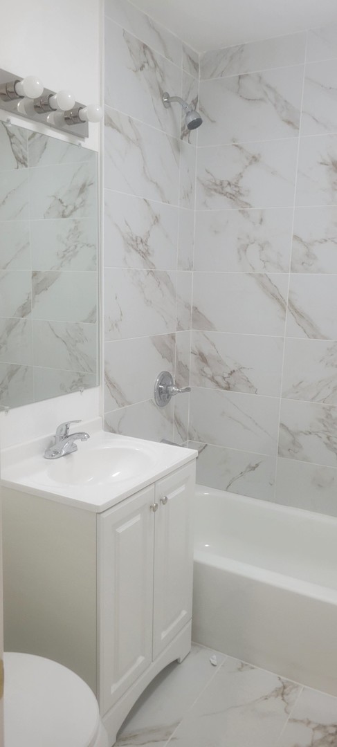 3207 North Wilton Avenue, Unit 2 Chicago, IL 60657 - Photo 14 of 14 a bathroom with a sink toilet and shower