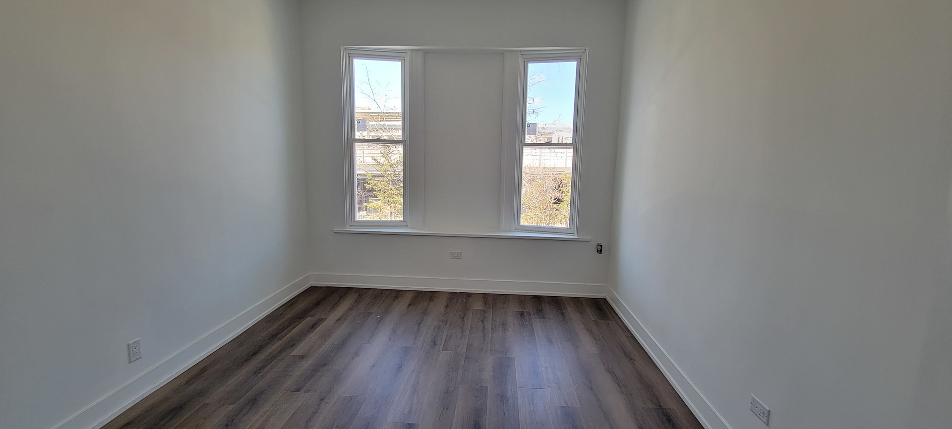 3207 North Wilton Avenue, Unit 2 Chicago, IL 60657 - Photo 3 of 14 an empty room with wooden floor and windows