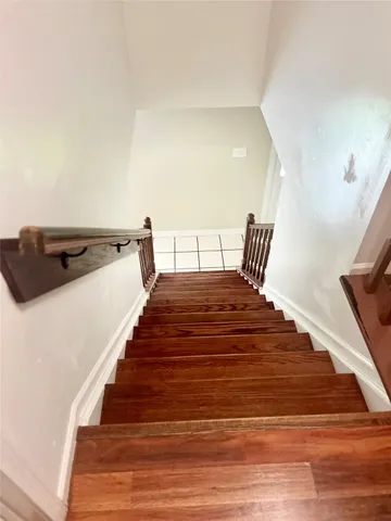 an empty room with wooden floor windows and ceiling fan