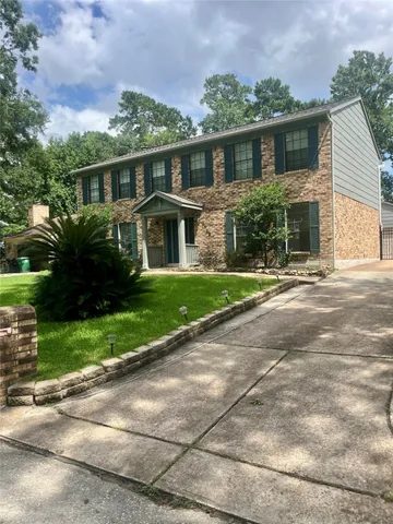 a front view of a house with a yard and potted plants
