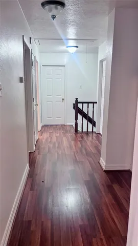 a view of a room with wooden floor and entryway