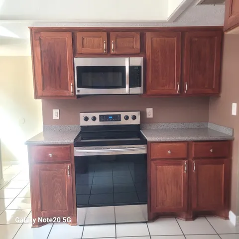 a kitchen with stainless steel appliances granite countertop a stove and a microwave