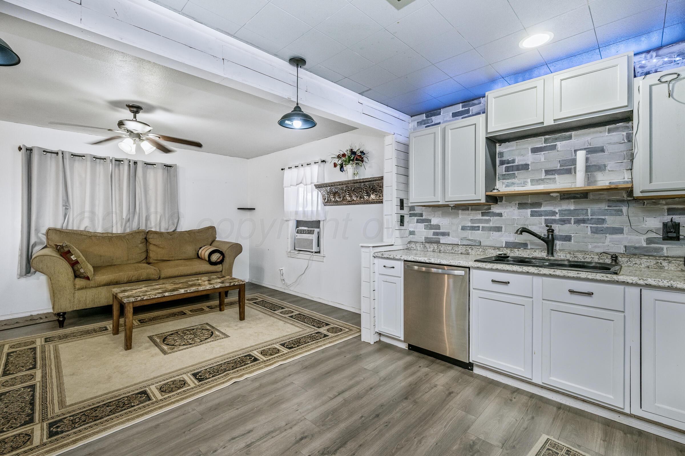 4429 Bowie Street Amarillo, TX 79110 - Photo 6 of 20 a kitchen with a refrigerator cabinets and wooden floor