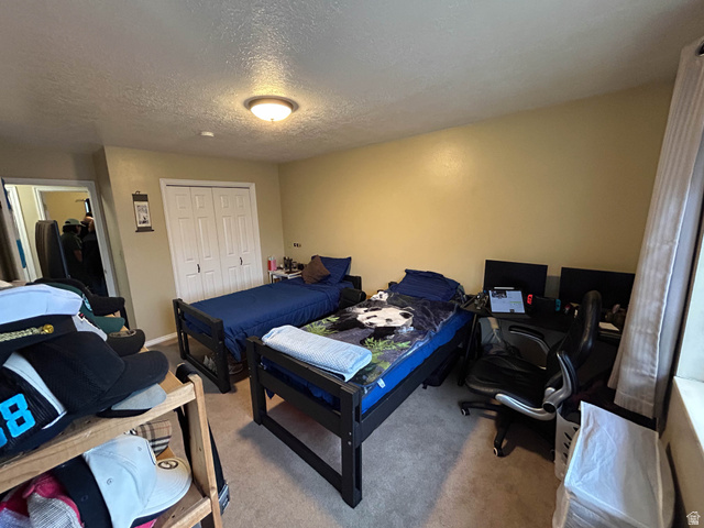 939 South Freedom Boulevard, Unit 13 Provo, UT 84601 - Photo 20 of 26 Bedroom with carpet flooring, a closet, a textured ceiling, and an office area