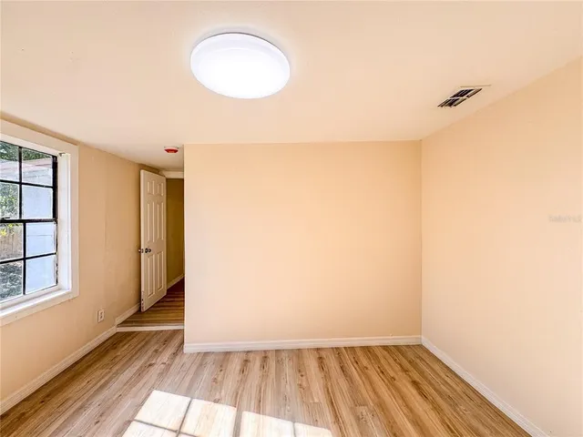 a view of a room with wooden floor and a window