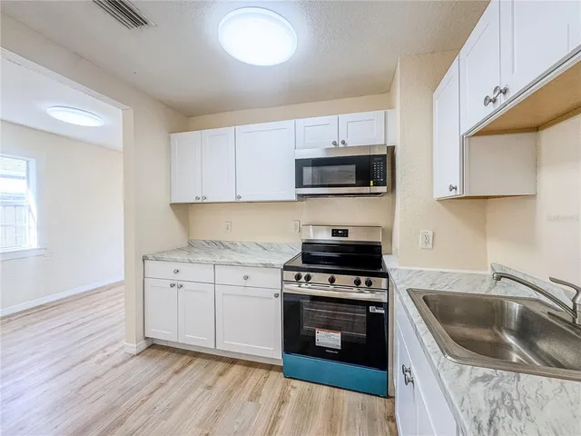 a kitchen with a sink a stove and cabinets