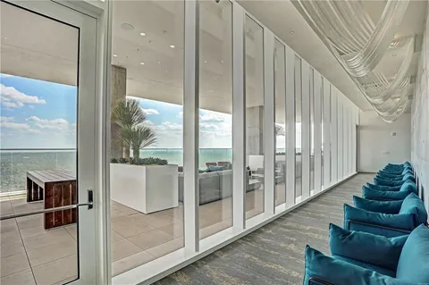 a living room with furniture and a floor to ceiling window