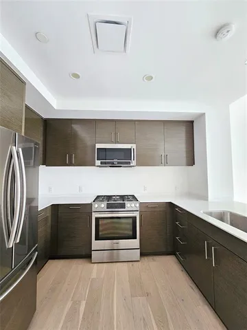 a kitchen with stainless steel appliances a stove and a sink