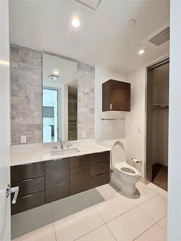 a bathroom with a sink a toilet and mirror