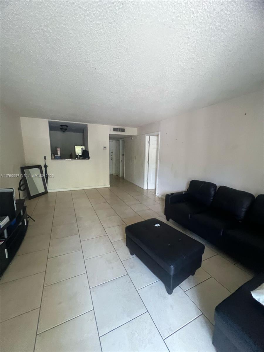 482 Northwest 165th Street, Unit A203 Miami, FL 33169 - Photo 3 of 6 a living room with a couch and a stove top open