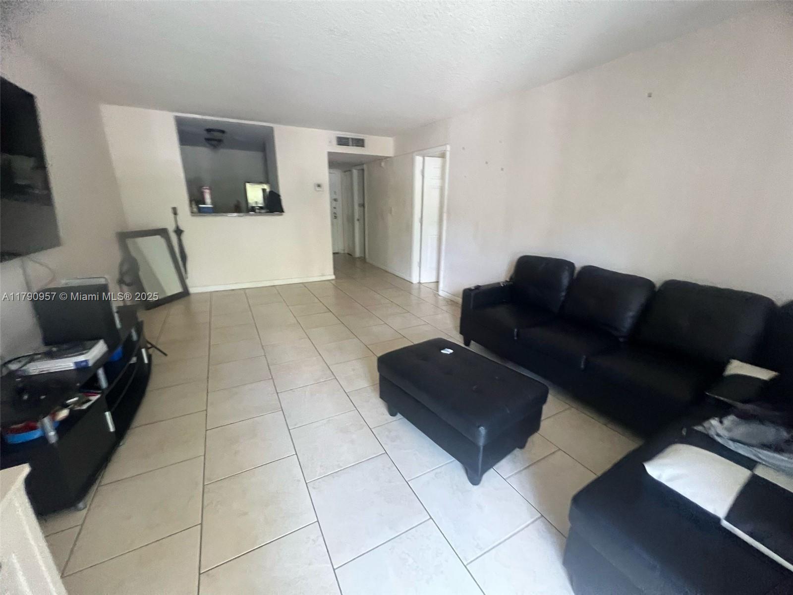 482 Northwest 165th Street, Unit A203 Miami, FL 33169 - Photo 4 of 6 a living room with furniture and a couch