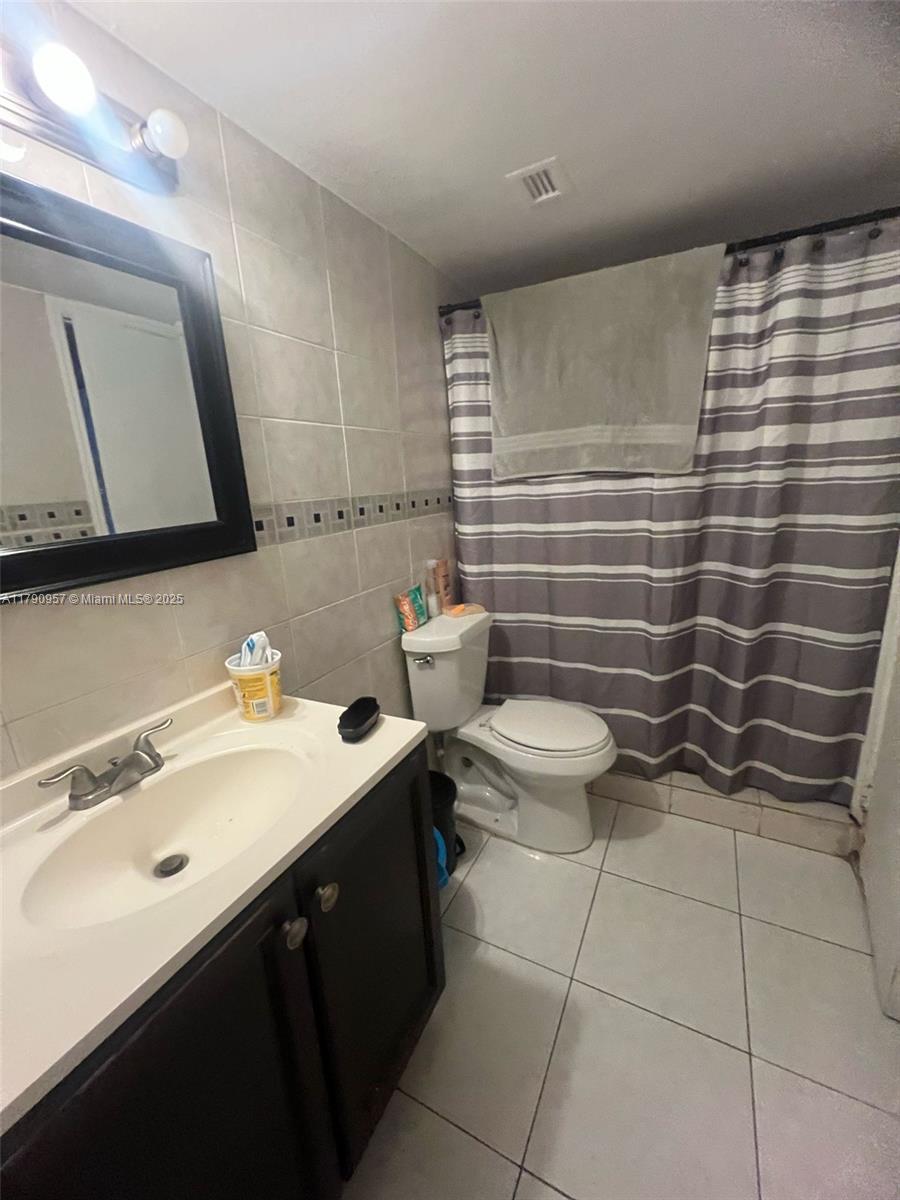 482 Northwest 165th Street, Unit A203 Miami, FL 33169 - Photo 5 of 6 a bathroom with a sink toilet and mirror