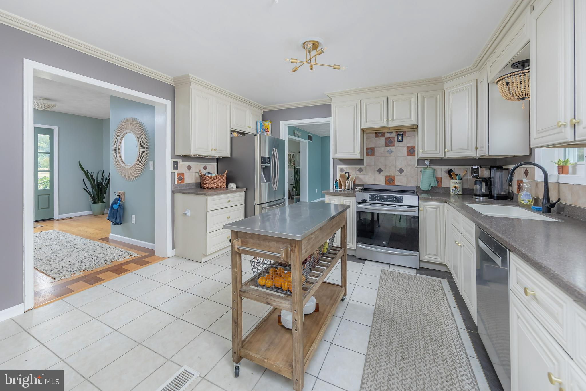 141 West Tomlin Station Road Mickleton, NJ 08056 - Photo 11 of 33 a kitchen with stainless steel appliances granite countertop a stove top oven a sink dishwasher a dining table and chairs with white cabinets