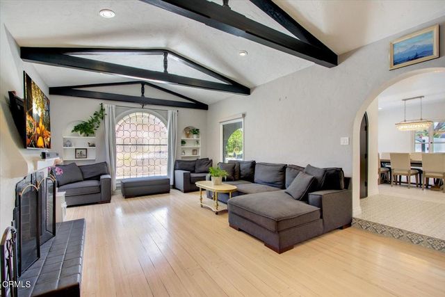 a kitchen with granite countertop a stove a sink a dining table and chairs