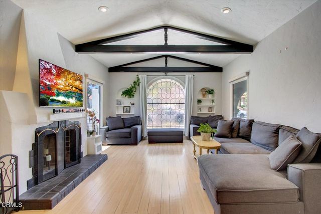 a kitchen with stainless steel appliances a sink a stove a refrigerator a counter space and chairs