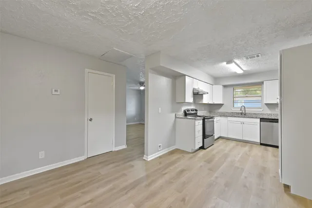 a kitchen with white cabinets and stainless steel appliances