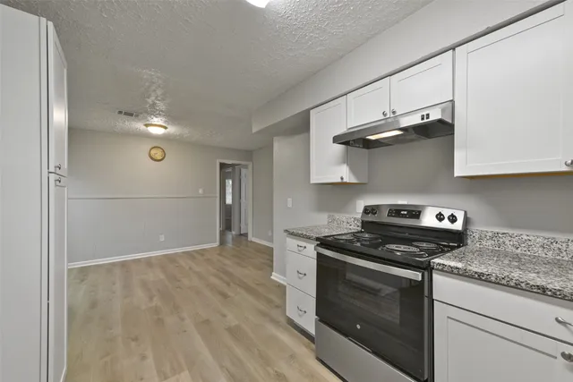 a kitchen with stainless steel appliances granite countertop a stove and a refrigerator