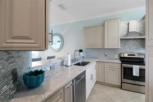 a kitchen with stainless steel appliances granite countertop a refrigerator and a sink