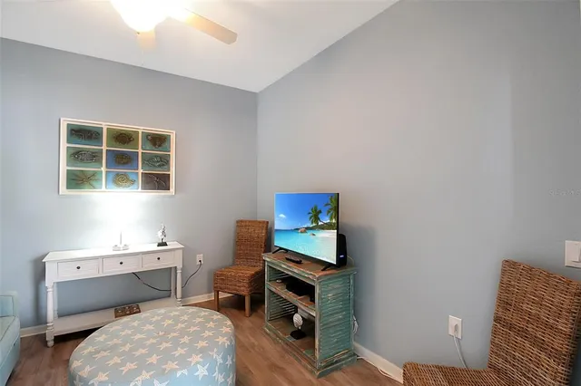 a living room with furniture a flat screen tv and a floor to ceiling window