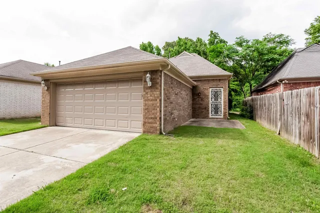a front view of a house with a garden and yard