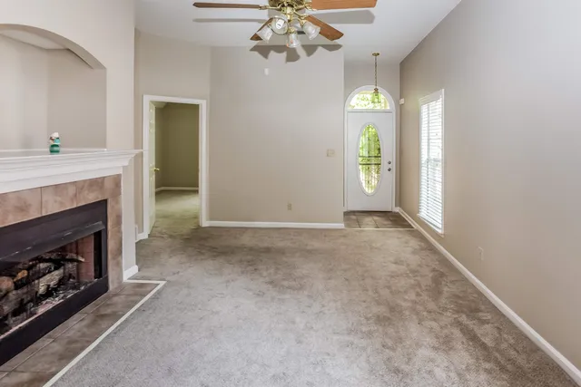 a view of an empty room with a fireplace and a window