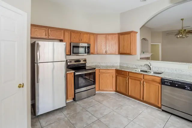 a kitchen with granite countertop cabinets stainless steel appliances and a sink