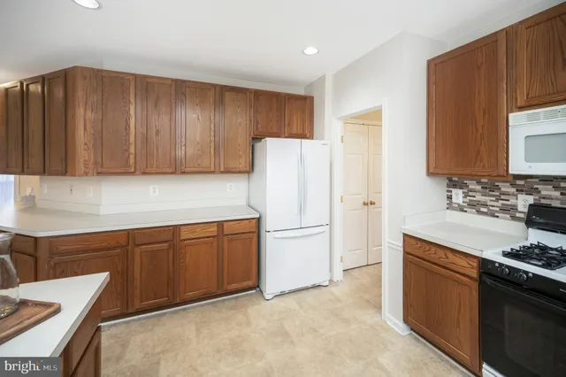 a kitchen with stainless steel appliances granite countertop a refrigerator stove a sink and dishwasher
