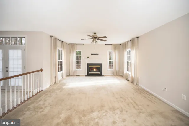 a view of an empty room with a fireplace and a window