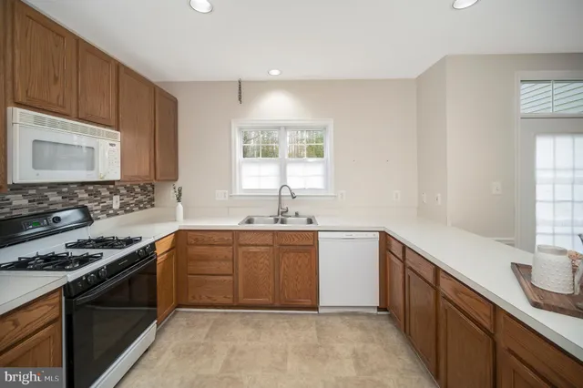 a kitchen with a sink stove top oven and cabinets