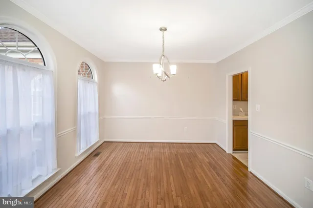 a view of a room with wooden floor and white walls