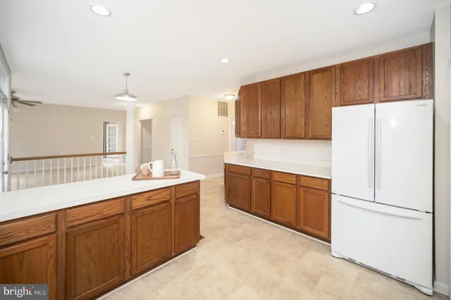 a kitchen with a sink a refrigerator and wooden cabinets