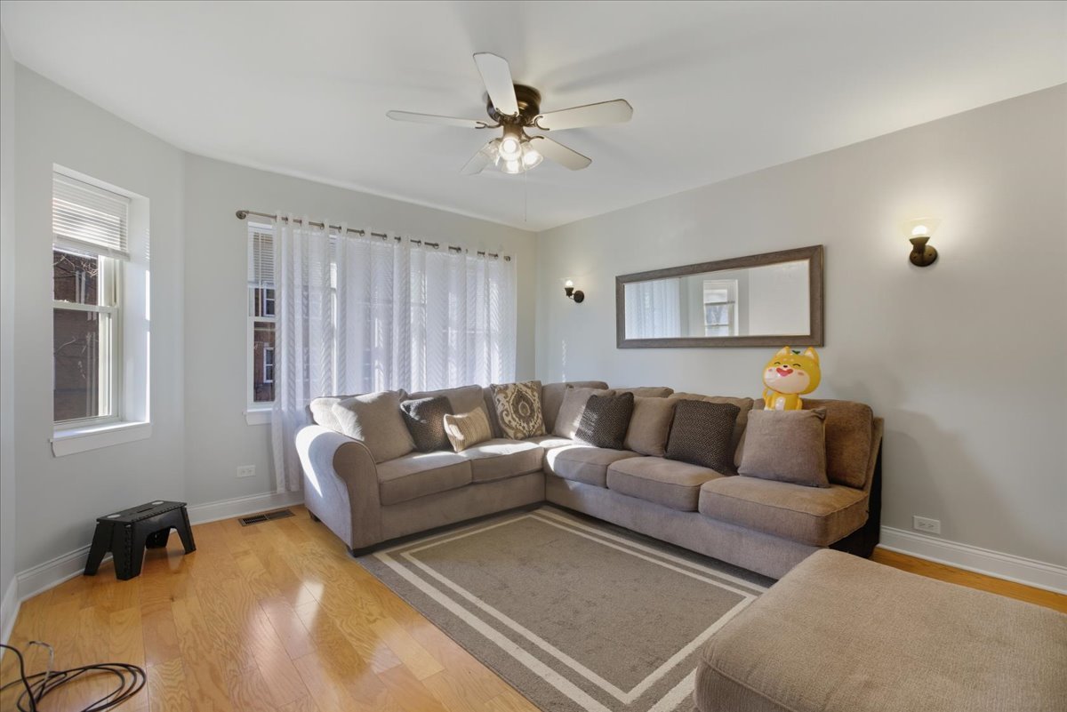 a living room with furniture and a ceiling fan